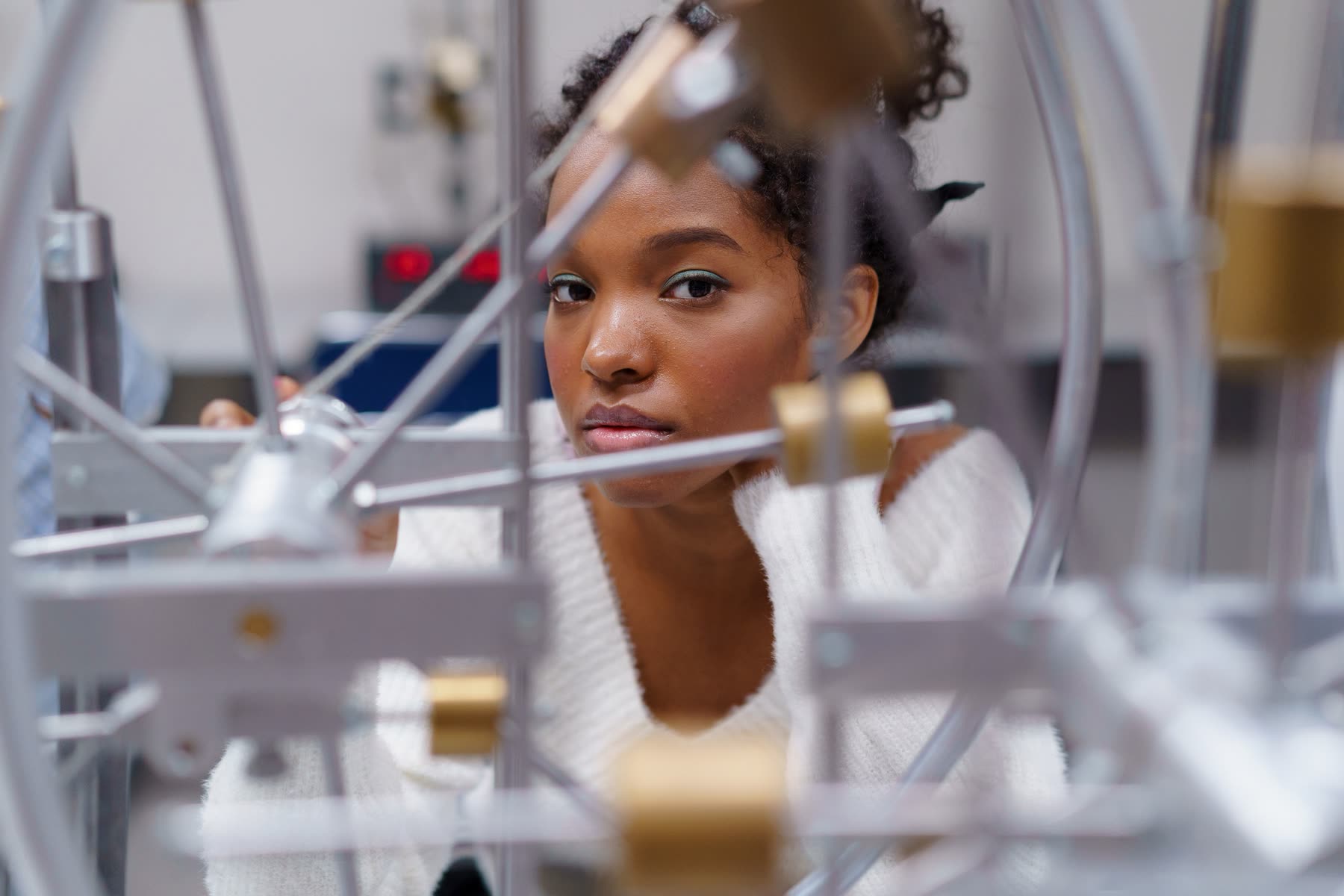 A high school student exploring scientific equipment in a classroom.